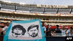 Argentina fans hold a banner with images of Argentina's forward Lionel Messi (R) and late Argentine football player Diego Maradona during the Conmebol 2024 Copa America tournament semi-final football match between Argentina and Canada at MetLife Stadium, 