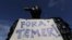 A demonstrator dressed in a black feathered costume holds a sign stating Brazil's President Michel Temer should "get out," during an anti-government protest in Brasilia, May 24, 2017. 