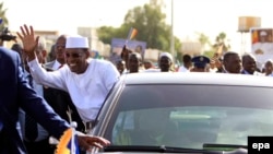 Le président tchadien Idriss Deby se penche de sa voiture pour saluer la foule après son arrivée à Khartoum, Soudan, 08 mars 2016. Deby a été proclame vainqueur au premier tour de l’élection présidentielle du 10 mars 2016 au Tchad avec plus de 69%. epa/ M