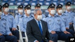 Israeli Prime Minister Benjamin Netanyahu wears a face mask as he attends a graduation ceremony for new pilots in Hatzerim air force base near the southern Israeli city of Beersheba, Israel, June 25, 2020.