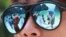 FILE - In this Thursday, May 31, 2018, photo, tourists are reflected in sunglasses on Maya Bay on Phi Phi island in Krabi province, Thailand. 