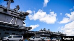 FILE - Seabees coordinate transportation of U.S. Navy sailors assigned to the aircraft carrier USS Theodore Roosevelt who have tested negative for coronavirus disease (COVID-19) to locations off base at Naval Base Guam, April 10, 2020. 