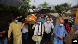 Anggota Partai Buruh Bharatiya Janta (BJP) membawa jenazah Rakesh Pandita yang tewas Rabu malam, di Jammu, India, Kamis, 3 Juni 2021. (AP Photo/Channi Anand)