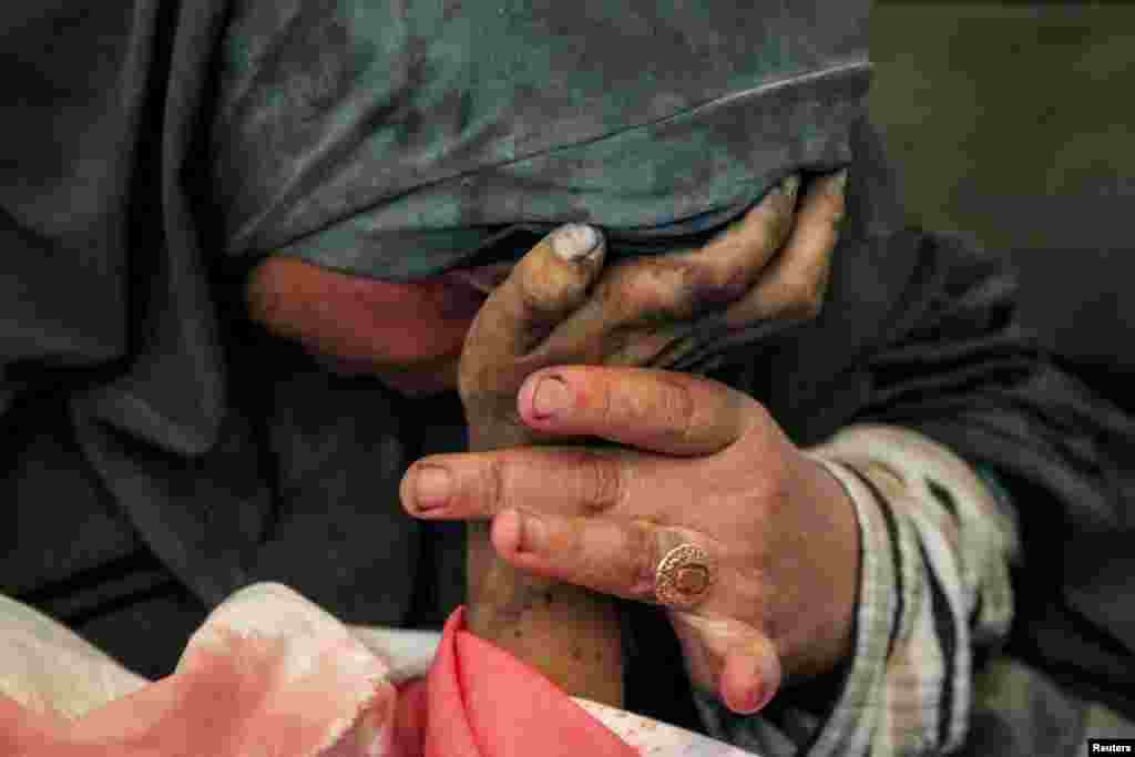 Palestinian woman Buthayna Abu Jazar reacts as she holds the hand of her son Hazma, who was killed in an Israeli strike&nbsp;in Rafah in the southern Gaza Strip amid the ongoing conflict between Israel and Hamas, May 9, 2024.