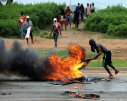 FILE - A protester sets a fire on the road in Abuja, Nigeria, Sept. 4, 2019. South African-owned businesses operating in Nigeria are being targeted with violence in retaliation for attacks carried out against Africans working in South Africa.