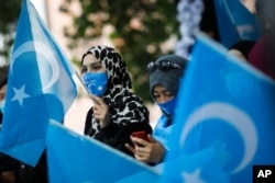 Uyghurs women take part in a protest during the visit of Chinese Foreign Minister Wang Yi in Berlin, Germany, Sept. 1, 2020.
