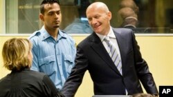 Bosnian Croat Jadranko Prlic, right, shakes hands with his lawyer prior to his judgment at the Yugoslav war crimes tribunal (ICTY) in The Hague, Netherlands, May 29, 2013. 