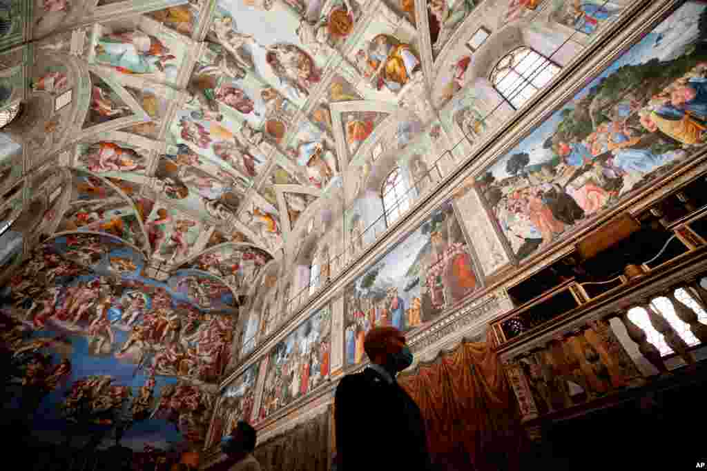 이탈리아의 바티칸 미술관 직원이 코로나 예방 마스크를 쓰고 시스티나 성당 안을 살피고 있다. 신종 코로나바이러스 여파로 닫혀있던 바티칸 미술관이 방문객들에게 다시 문을 열었다. 