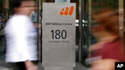 Pedestrians pass the head offices of mining giant BHP Billiton in Melbourne, Australia November 27, 2008 (file photo).