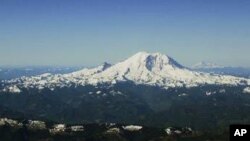 Mount Rainier stands in the foreground, framed in the background by Mount Adams, far left, Mount Hood, second left, and Mount St. Helens, right, in this aerial view