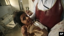 A member of the hospital staff carries a child injured in an attack at a local hospital in Peshawar, Pakistan, September 13, 2011.