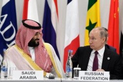 FILE - Saudi Arabia's Crown Prince Mohammed bin Salman, left, talks with Russian President Vladimir Putin during a G-20 summit event in Osaka, Japan, June 28, 2019.