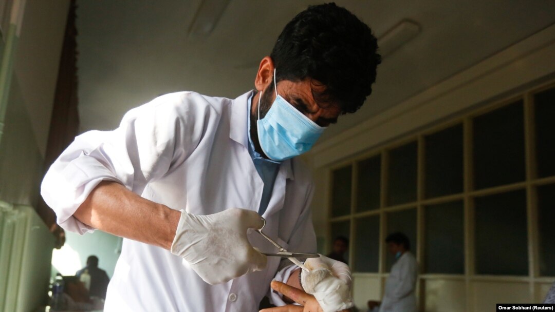 Seorang dokter merawat seorang pria yang terluka di sebuah rumah sakit setelah ledakan bom di sebuah rumah sakit militer di Kabul, Afghanistan, 9 Maret 2017. (Foto: REUTERS/Omar Sobhani)