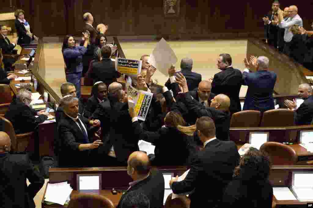 Israeli Arab members hold signs in protest as security pushes them out as U.S. Vice President Mike Pence speaks in Israel's parliament in Jerusalem.