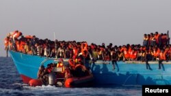 2016年8月29日利比亚海岸救助艇接近一个挤满移民的木船实施援救。
