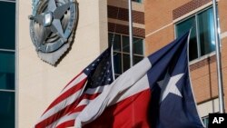 ARCHIVES - Un drapeau américain et un drapeau du Texas sont en berne devant le quartier général de la police de Dallas, le 8 juillet 2016
