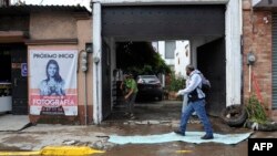 A villager removes mud off the street after heavy rains that caused a flood in Ecatepec, Mexico, on September 7, 2021.