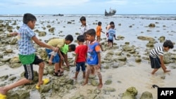 Children of newly-arrived Rohingya refugees are seen at a beach on Sabang island, Aceh province, Indonesia, on December 2, 2023. (Photo by CHAIDEER MAHYUDDIN / AFP)