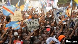 FILE - Supporters of Congolese opposition leader Etienne Tshisekedi carry placards and flags as they attend a political rally in the Democratic Republic of Congo's capital Kinshasa, July 31, 2016.