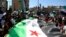Syrian protesters, wearing the colors of opposition, attend an anti-government demonstration in the rebel-held northern Syrian city of Idlib, Sept. 28, 2018.