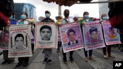 ARCHIVO - Familiares y compañeros de clase de los 43 estudiantes de colegio desaparecidos de Ayotzinapa marchan en Ciudad de México el 26 de septiembre de 2022 en el aniversario de la desaparición en Iguala, en el estado de Guerrero. 