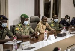 FILE - Col. Assimi Goita, center, self-declared leader of the National Committee for the Salvation of the People, and other officials from the group meet with a delegation from the West African regional bloc known as ECOWAS, in Bamako, Mali, Aug. 22, 2020.