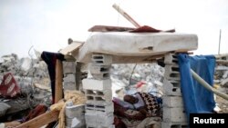 Palestinac u improvizovanom skloništu pored ruševina svoje kuće, za koju očevici kažu da je uništena u izraelskoj ofanzivi u Han Junisu 13. avgusta 2014. 