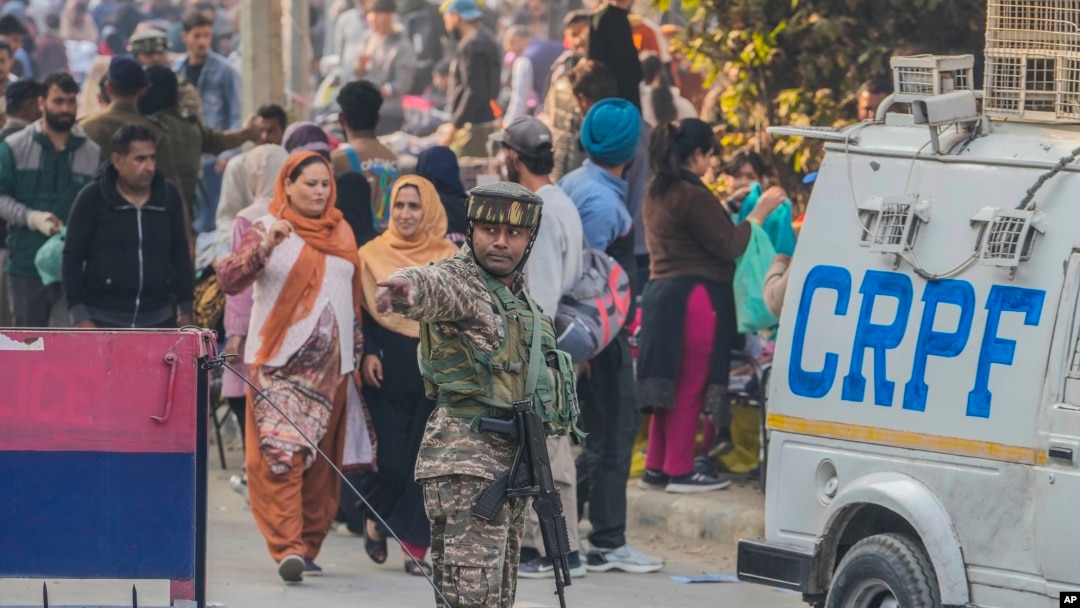 Seorang tentara paramiliter India berjaga sementara yang lain memeriksa lokasi ledakan granat di sebuah pasar di Srinagar, Kashmir yang dikuasai India, Minggu, 3 November 2024. (Foto: AP)