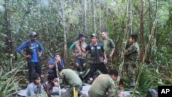 En esta foto difundida por la Oficina de Prensa de las Fuerzas Armadas de Colombia, soldados y hombres indígenas posan para una foto con los cuatro hermanos indígenas que llevaban 40 días desaparecidos en la selva de Solano, Colombia, el viernes 9 de junio de 2023. 