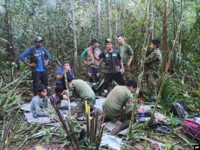 En esta foto difundida por la Oficina de Prensa de las Fuerzas Armadas de Colombia, soldados y hombres indígenas posan para la foto con los cuatro hermanos indígenas que llevaban 40 días desaparecidos, en la selva de Solano, estado de Caquetá, Colombia, el viernes 9 de junio de 2023. (Oficina de Prensa de las Fuerzas Armadas de Colombia)