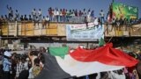 Sudanese protesters wave a national flag during a "million-strong" march outside the army headquarters in the capital Khartoum April 25, 2019.