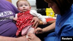 FILE - Lauren Durbin, aged 10 months, is given an MMR injection by Sister Sian Owen at the Paediatric Outpatients department at Morriston Hospital in Swansea, south Wales, April 6, 2013. 