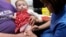 FILE - Lauren Durbin, aged 10 months, is given an MMR injection by Sister Sian Owen at the Paediatric Outpatients department at Morriston Hospital in Swansea, south Wales, April 6, 2013. 