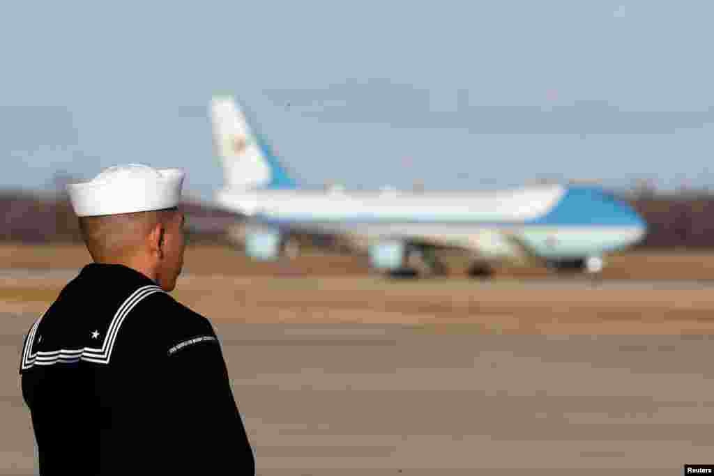 A sailor from the USS George H.W. Bush aircraft carrier watches as the plane carrying the casket of late former U.S. President George H.W. Bush arrives at Andrews Air Force Base, Maryland, Dec. 3, 2018. 