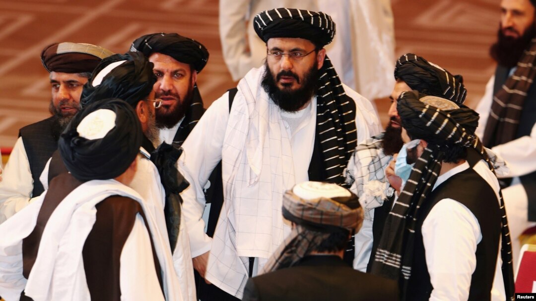 FILE - Taliban delegates speak during talks between the Afghan government and Taliban insurgents in Doha, Qatar, Sept. 12, 2020.