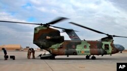 In this Jan. 13, 2020, photo, a U.S. Air Force helicopter sits at Ain al-Asad air base, in Anbar, Iraq. The U.S.-led coalition pulled out from a base in the country's west as part of plans to drawdown on March 19, 2020, amid fears of a viral pandemic. 