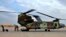 In this Jan. 13, 2020, photo, a U.S. Air Force helicopter sits at Ain al-Asad air base, in Anbar, Iraq. The U.S.-led coalition pulled out from a base in the country's west as part of plans to drawdown on March 19, 2020, amid fears of a viral pandemic. 