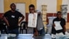 Funcionários da assembleia de voto organizam os boletins de voto antes de procederem à contagem numa assembleia de voto em Windhoek, Namíbia, em 1 de dezembro de 2024.