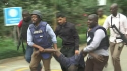 Kenya Police Carry Injured Man from Scene