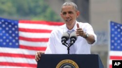 With the Key Bridge, linking Washington and Northern Virginia in the background, President Barack Obama speaks about the economy and transportation at Georgetown Waterfront Park in Washington, July 1, 2014.