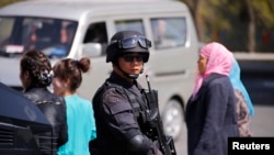 Police from Special Weapons and Tactics (SWAT) team stand guard outside the South Railway Station, where three people were killed and 79 wounded in a bomb and knife attack on Wednesday, in Urumqi, Xinjiang, Uighur Autonomous region, May 1, 2014.