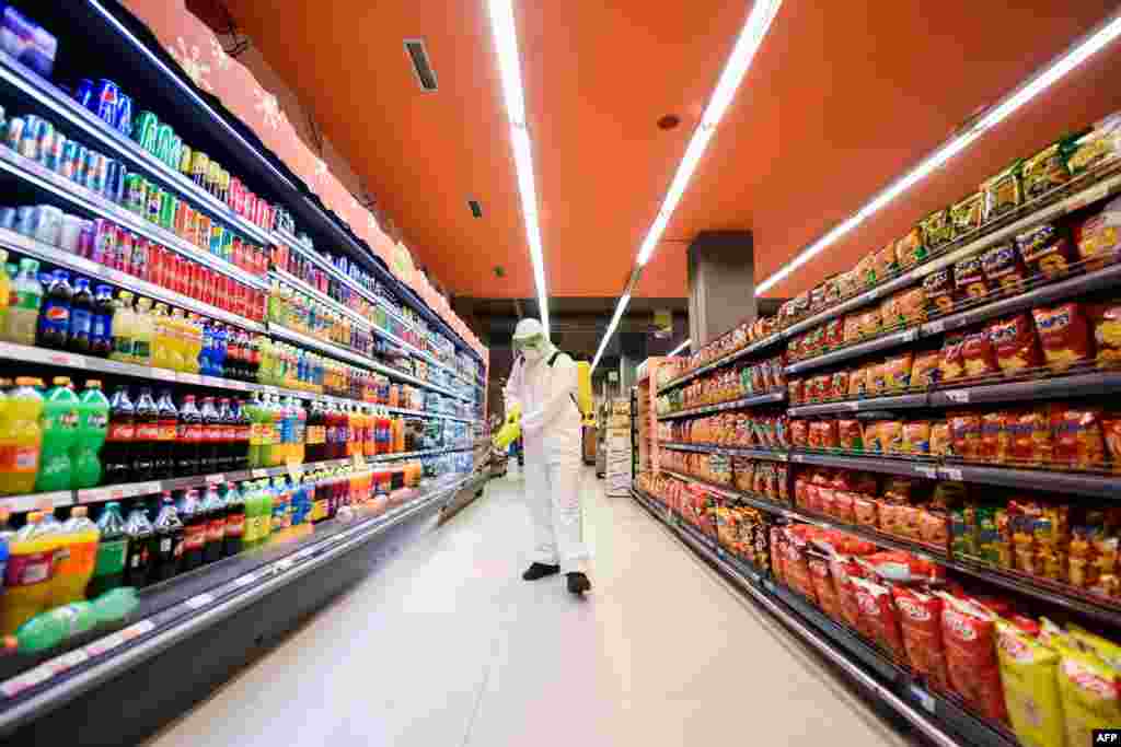 A worker disinfects the floor of a supermarket as a preventive measure against the spread of the new coronavirus, COVID-19, in Pristina, Kosovo.