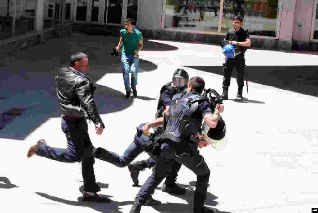 Turkish riot police try to protect a person from a group of people of unknown affiliation who were attacking a rally of pro-Kurdish Peoples&#39; Democracy Party, (HDP) in eastern city of Erzurum.
