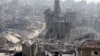 FILE PHOTO: People walk past the rubble of destroyed buildings, in Jabalia in the northern Gaza Strip