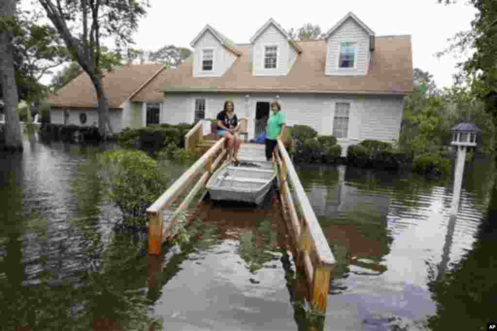 Lechelle, right, and her daughter Haleigh Spalding sit in front of their flooded home after a storm surge on the Outer Banks in Kitty Hawk, N.C., Sunday, Aug. 28, 2011 in the aftermath of Hurricane Irene after it left the North Carolina coast. (AP Photo/C