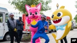 In this Oct. 25, 2019, photo, Pinkfong and Baby Shark cheer on the Washington Nationals with fans ahead of Game 3 of the World Series.