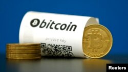 FILE - A Bitcoin (virtual currency) paper wallet with QR codes and a coin are seen in an illustration picture taken at La Maison du Bitcoin in Paris, France, May 27, 2015. 