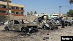 Seorang pria memeriksa rongsokan mobil setelah ledakan bom mobil di distrik Kadhimiya, Baghdad hari Senin (30/9). 