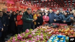 Chinese President Xi Jinping talks to residents as he visits a food market in Shenyang, Liaoning Province, on Jan. 23, 2025, ahead of the Lunar New Year. (Xinhua News Agency via AP)