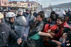 Migrants scuffle with Greek police at the port of Mytilene after locals block access to the Moria refugee camp, on the northeastern Aegean island of Lesbos, Greece, March 3, 2020.
